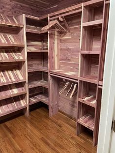 an empty walk in closet with wooden shelves