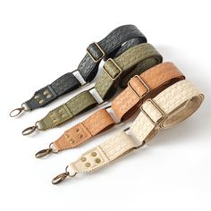 four different colored belts are lined up on a white surface