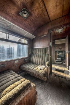 the inside of a train car with two couches and a mirror on the wall