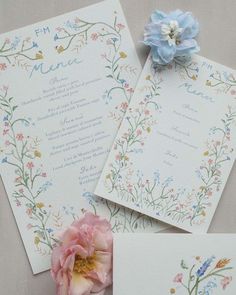 the wedding stationery is laid out on top of each other, with a flower