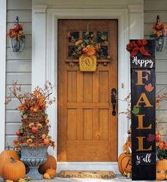 a front door decorated with fall decorations and pumpkins