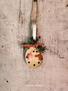 a christmas ornament hanging on a wall with a fork in it's mouth