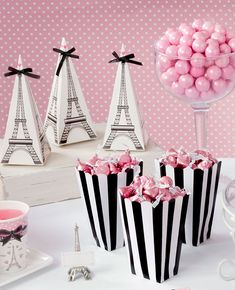 pink and black striped bags with bows on them next to other small white boxes filled with candies