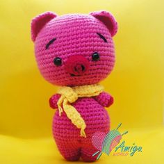 a pink crocheted stuffed animal with a yellow ribbon around its neck