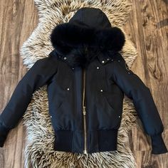 Gorgeous Gently Used Black With Gold Tone Hardware Guc Moose Knuckles Debbie Bomber Jacket 80/20 Down Fill Worn A Handful Of Times. So Warm And Flattering On! The Only Reason I’m Selling Is Because I Had A Baby And I’m Needing To Size Up This Season. I Did Wear This A Couple Of Times And I Do Like To Be 100% Honest With Everything I Sell - Minor Wear On Sleeves As Pictured. One Of The Puffs Came Off But This Can Be Easily Fixed By A Dry Cleaner Or Seamstress. Size Xs/S I Do Have A Second Listing Designer Fitted Fur Coat For Winter, Luxury Fur Coat For Cold Weather, Designer Faux Fur Trim Winter Coat, Designer Winter Outerwear With Faux Fur Lining, Luxury Winter Fur Coat With Padded Collar, Luxury Faux Fur Trim Outerwear For Cold Weather, Luxury Fur Coat With Padded Collar For Winter, Luxury Outerwear With Faux Fur Trim For Cold Weather, Designer Black Winter Fur Coat