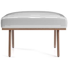 a white bench with wooden legs and an upholstered seat on it's side