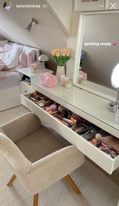 a vanity with drawers and a mirror above it in a small room next to a bed