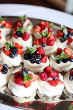 red velvet cupcakes with white frosting and fresh berries on top are arranged in a box