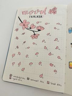 an open notebook with pink flowers and the words travel tracker written in black on it