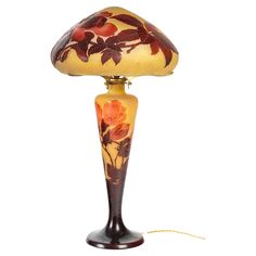 a lamp that is sitting on top of a wooden base and has flowers painted on it