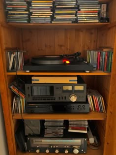 an old record player is sitting on top of a shelf full of dvds and cds