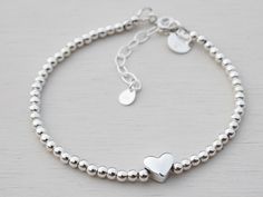 A dainty sterling silver bracelet made with 3mm silver beads and a solid silver heart. This bracelet looks lovely on it's own or stacked up with a few of them! The length of the bracelet is approximately 17cm with a 4cm extension chain.  There is also a 'Made with ♥' charm at the clasp. Beautifully presented in a tinysilver faux suede pouch. Bead Heart, Silver Bead, Sterling Silver Bracelet, Heart Bracelet, Heart Charm Bracelet, Diamond Heart, Adjustable Bracelet, Silver Heart, Silver Beads