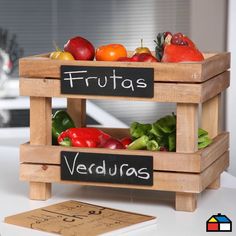 two wooden crates filled with vegetables on top of a white counter next to a sign that says fruits and veggies