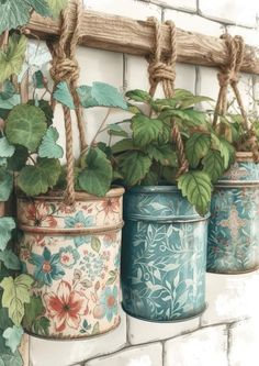 three flower pots with plants in them hanging on a brick wall