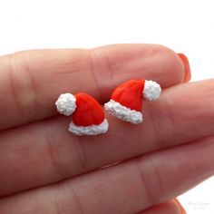 Santa Hat Stud Earrings. The size of a hat is about 13x11 mm (0.5x0.4 inch) Other earrings you can see here: https://www.etsy.com/shop/RinaStudioDesign?section_id=24005662 * Submersion in water is not recommended for polymer clay as this will quickly deteriorate the product. It is recommended that you remove the earrings prior to swimming or showering to extend the life of the product. * Due to the handmade quality of all products, each one will vary slightly in appearance. While I do my very best to make them as similar as possible exact replication is not possible. * All items are packaged in a gift boxes to avoid any damage during the delivery. To reduce waste and shipping costs, multiple items will be packaged together. If you'd like separate boxes or have other special shipping reques Adjustable Earrings For Christmas Gift, Adjustable Earrings As A Christmas Gift, Novelty Red Christmas Jewelry, Red Novelty Christmas Jewelry, Red Christmas Novelty Jewelry, Red Novelty Jewelry For Christmas, Red Earrings For Winter Gift, Cute Red Christmas Earrings, Cute Red Earrings For Christmas