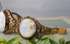 "Here's an antique carved shell cameo bracelet, set in 10k gold. It features 3 cameos, the middle one being larger than the two on the sides. The setting has a delicate openwork construction of leaves, mounted onto a wire backing. The center link is 1.1/2\" wide, and the two sides are 1.1/4\". It has a hidden box clasp and safety chain, and is stamped, '10k' on the back of the clasp. Interior circumference is 7\". Completely original with no repairs and no damage. Thanks for looking." Elegant Gold Cameo Bracelets, Antique Cabochon Bracelets For Wedding, Elegant Cameo Bracelet Jewelry, Ornate Cameo Jewelry For Formal Occasions, Vintage Carved Jewelry For Formal Occasions, Elegant Cameo Bracelet For Formal Occasions, Elegant Cameo Wedding Bracelets, Elegant Wedding Cameo Bracelets, Vintage Intaglio Bracelets For Formal Occasions