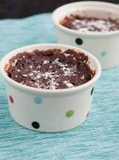 two white bowls filled with brownies on top of a blue table cloth and polka dot napkin