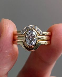 a person holding a gold ring with a diamond on it