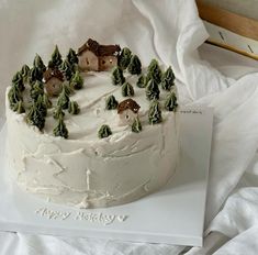 there is a cake with white frosting and trees on it