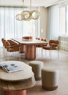 a dining room table surrounded by chairs and stools in front of a large window