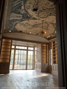 a large room with wood paneled walls and a ceiling painted with a world map