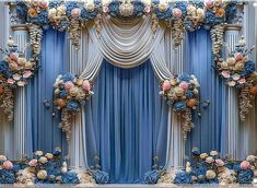 a stage decorated with blue curtains and flowers on the side, for a wedding ceremony