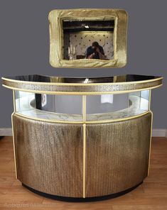 a gold and black cabinet with a mirror on top