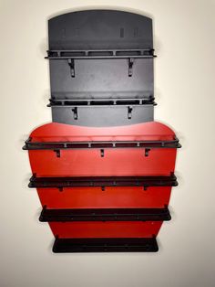 three suitcases stacked on top of each other in the shape of a heart, hanging from a wall