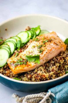 roasted salmon with quinoa bowls and cucumbers in a bowl on a table