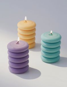 three candles sitting next to each other on a white surface