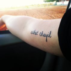 a person with a tattoo on their arm that reads, what's chiqui?