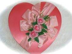 a pink heart shaped box with flowers on it