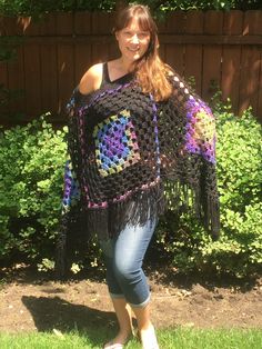 This beautiful, hand-crocheted poncho is a classic,  It is made of extra-soft acrylic and wool yarns.  The main color is black with green, blue and purple accents. This poncho is the perfect accessory.  Ideal for an summer evening at a festival or an early spring/fall hike. You can wear it over a coat or light jacket.  Ponchos are versatile and always in style. This stylish and super-soft poncho is easy to care for:  Machine wash in cool water.  Lay flat to dry.  Do not dry clean. Size:  One Siz Black Bohemian Poncho Shawl, Bohemian Black Poncho For Fall, Black Bohemian Poncho One Size, Black Shawl Poncho For Festival, Black Bohemian Crochet Poncho, Black Shawl Poncho One Size, Handmade Black Poncho For Festivals, Handmade Black Shawl Poncho, Handmade Black Poncho One Size