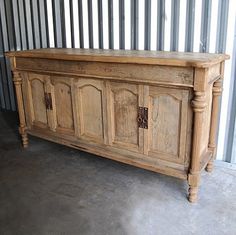 an old wooden cabinet sitting in front of a striped wall