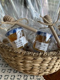 three jars of honey sit in a wicker basket with twine and plastic bags