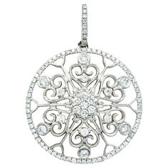 Radiating with timeless charm, this captivating diamond pendant is an embodiment of elegance and sophistication. Set in opulent 14 karat white gold, the pendant takes the form of a resplendent circle adorned with an intricate scroll-like design. Within the circular frame, an array of dazzling diamonds is meticulously set, creating a brilliant tapestry of light and sparkle. The scattered diamonds on the scroll-like pattern add a touch of whimsy and playfulness to the overall design, enhancing the pendant's allure. The meticulous craftsmanship extends to the finer details, with delicate milgrain design throughout the piece, adding a vintage-inspired touch. The pendant strikes a harmonious balance between classic and contemporary aesthetics, making it a versatile and enduring piece of jewelry Circular Frame, Circle Pendant, Diamond Clarity, Diamond Pendant, Colored Diamonds, Round Diamonds, Metallica, Jewelry Necklace Pendant, Diamond Cuts