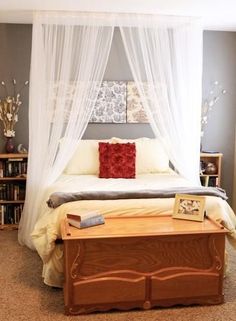 a bedroom with a bed, dresser and bookshelf on the floor in front of it