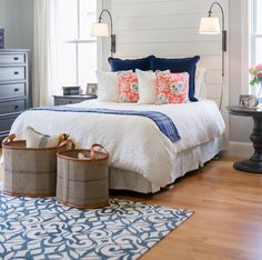 a bedroom with blue and white bedding, two lamps on either side of the bed