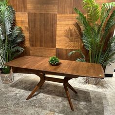 a wooden table surrounded by potted plants