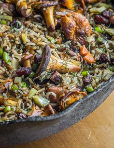 a pan filled with rice and vegetables on top of a wooden table