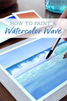 someone is painting a watercolor wave on paper with a pen and ink in their hand