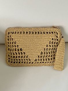 a crocheted straw purse on a white surface