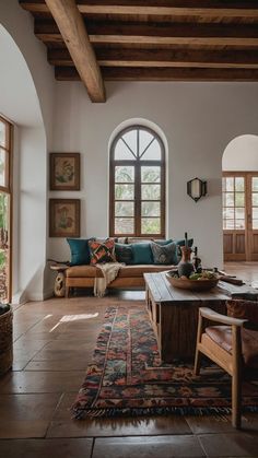 a living room filled with lots of furniture next to a large arched window on top of a wooden floor