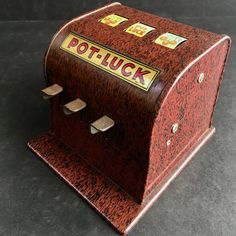 an old fashioned coin operated machine sitting on a table with the word potluck written on it