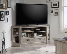 a flat screen tv sitting on top of a wooden entertainment center in a living room