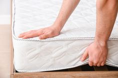 a close up of a person's hand on a mattress