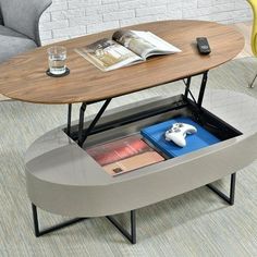 a coffee table with an open drawer underneath it and a game controller on the other side