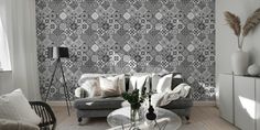 a living room filled with furniture and a wall covered in black and white wallpaper