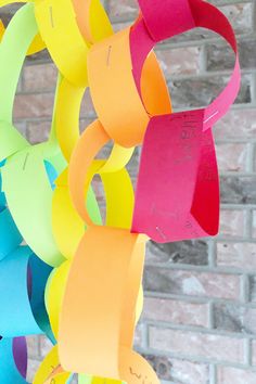 colorful paper circles hanging from a brick wall