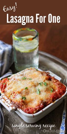 lasagna casserole served on a serving tray with a glass of water